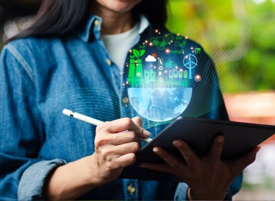 Person mit Tablet und digitaler Darstellung von nachhaltiger Energie und Industrie