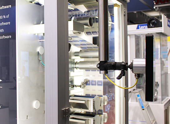 Winding machine with several rolls and belts in an open housing