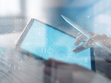 Person, die ein Tablet in der Hand h&auml;lt und darauf zeichnet. Im Vordergrund sind schematische Darstellungen von Zahnr&auml;dern.