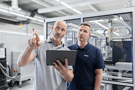 Zwei Service Kollegen in einer Halle mit Tablet in der Hand