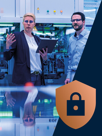 2 persons in a production environment talking and holding a tablet