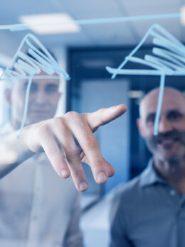 Two people sketching plant concept on glass wall for engineering and industrial automation