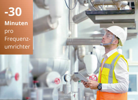 Man in der Fertigung, welcher einen Sicherheitshelm trägt und eine Installation abnimmt